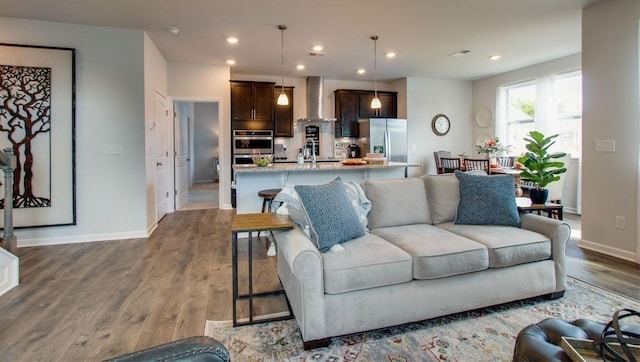 living room featuring visible vents, recessed lighting, baseboards, and wood finished floors