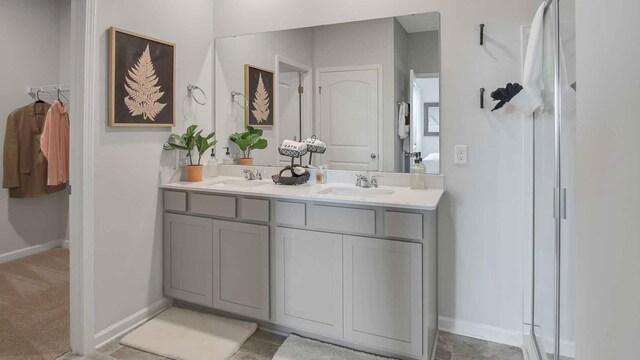 full bath with double vanity, baseboards, and a sink