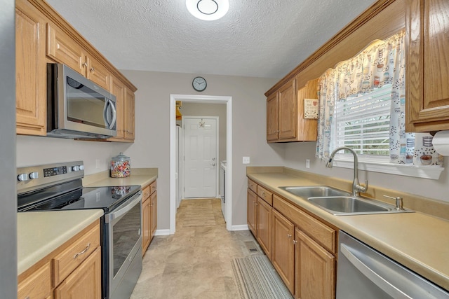 kitchen featuring a sink, light countertops, baseboards, and stainless steel appliances