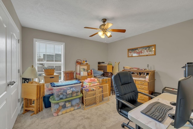 home office featuring carpet flooring, a textured ceiling, and a ceiling fan