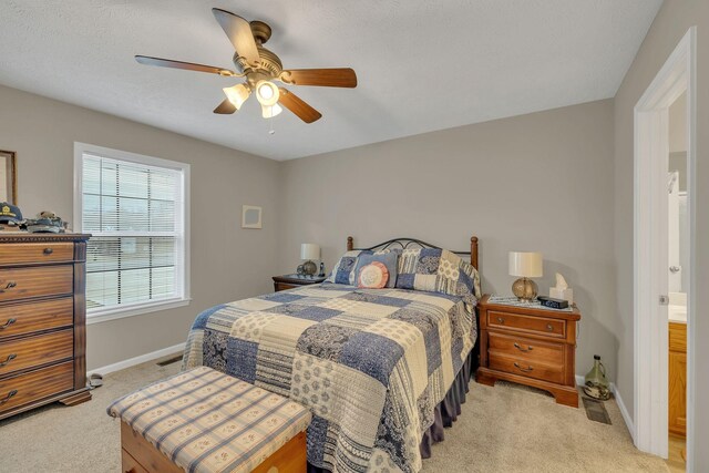 bedroom with visible vents, baseboards, light colored carpet, and ceiling fan