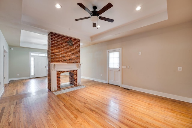 4509 Wyoming Ave, Nashville, TN 37209 - unfurnished living room featuring a tray ceiling, light wood-style flooring, baseboards, and ceiling fan