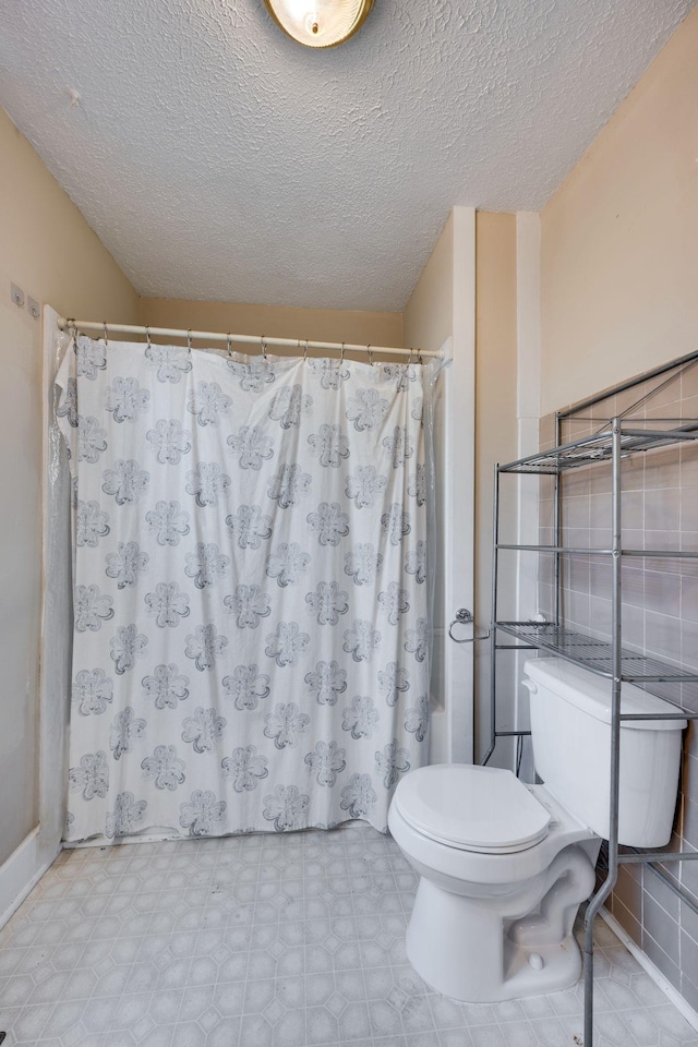 4509 Wyoming Ave, Nashville, TN 37209 - full bath with a shower with shower curtain, toilet, tile patterned floors, and a textured ceiling