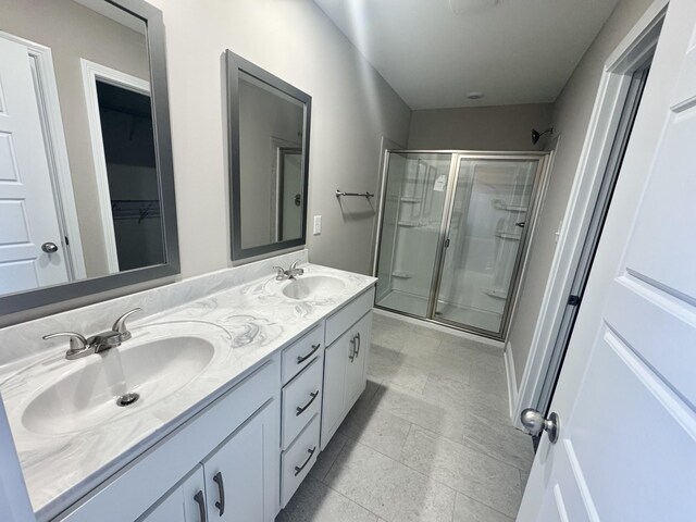 153 Cardinal Crk, Clarksville, TN 37040 - bathroom featuring a stall shower, double vanity, and a spacious closet
