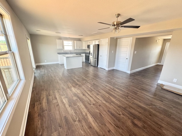 153 Cardinal Crk, Clarksville, TN 37040 - unfurnished living room with dark wood-type flooring, a sink, a ceiling fan, and baseboards