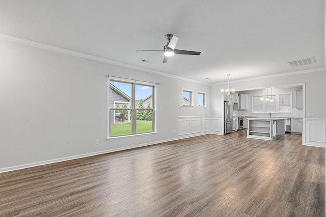 unfurnished living room featuring ornamental molding, visible vents, dark wood-style flooring, and ceiling fan with notable chandelier