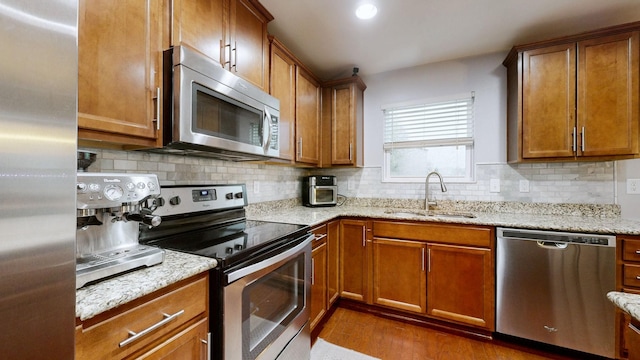 1504 Rockwood Ln, Lebanon, TN 37087 - kitchen featuring tasteful backsplash, brown cabinets, appliances with stainless steel finishes, and a sink
