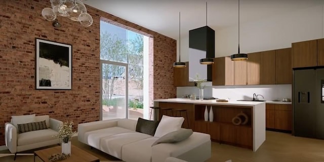 living area with a healthy amount of sunlight, brick wall, and a towering ceiling