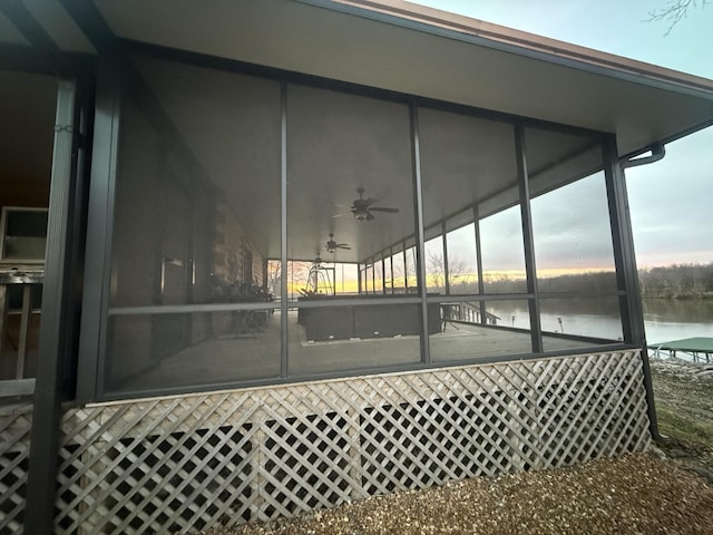exterior space with a water view, a ceiling fan, and a sunroom