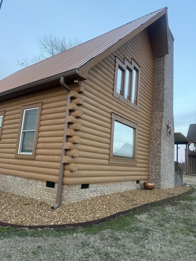 view of side of property with crawl space and metal roof