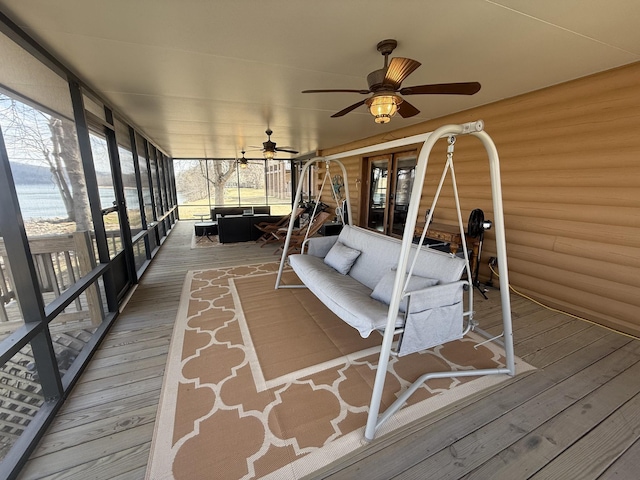 unfurnished sunroom featuring a ceiling fan