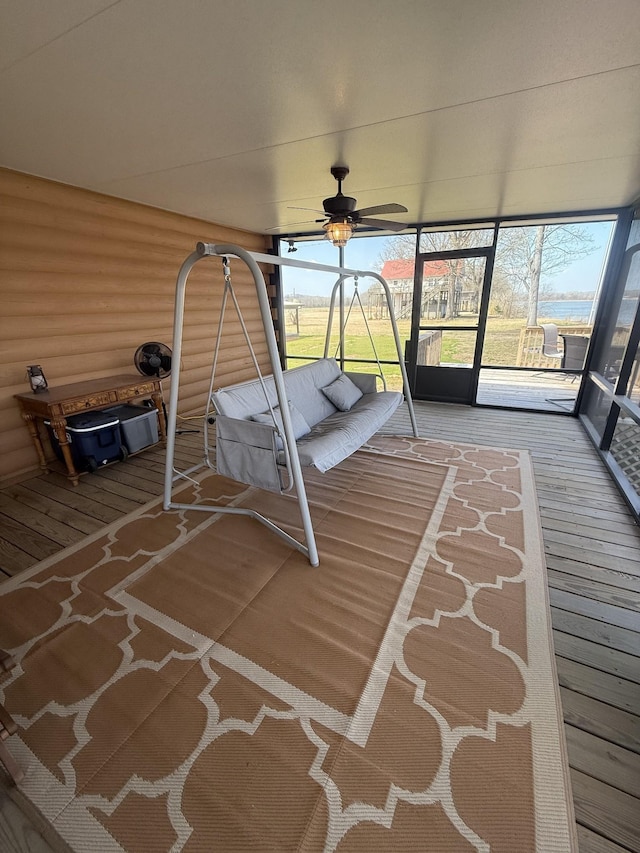 unfurnished sunroom featuring ceiling fan