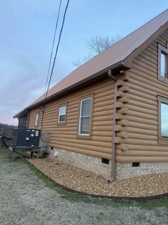 view of side of home featuring crawl space, metal roof, and log siding