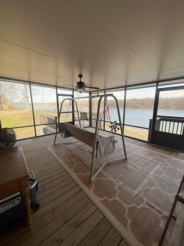 unfurnished sunroom with a water view and a ceiling fan
