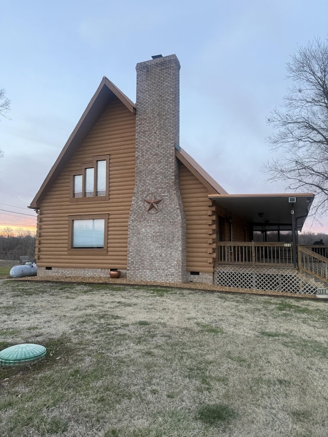 view of property exterior featuring crawl space, a chimney, a yard, and log siding