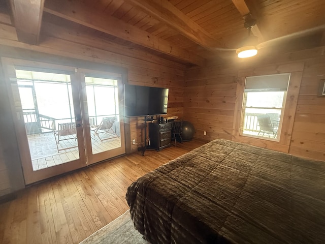 bedroom featuring beam ceiling, wood ceiling, light wood-style floors, wood walls, and access to outside