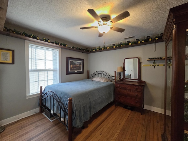 bedroom with ceiling fan, a textured ceiling, baseboards, and hardwood / wood-style flooring