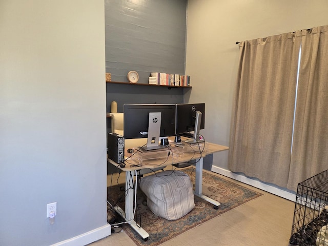 office area with baseboards and concrete flooring