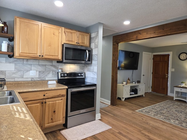 kitchen featuring light countertops, wood finished floors, tasteful backsplash, and stainless steel appliances