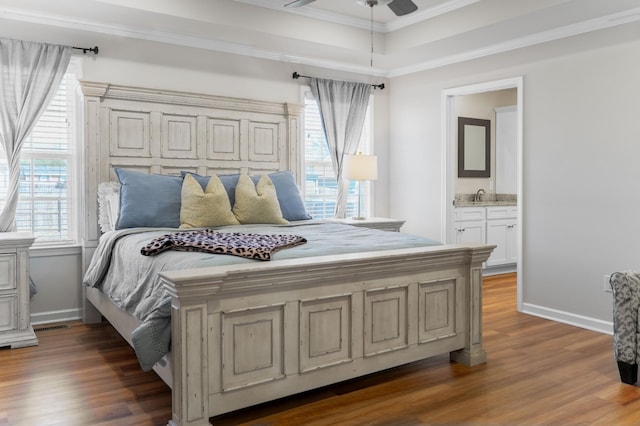 bedroom with a sink, multiple windows, wood finished floors, and crown molding