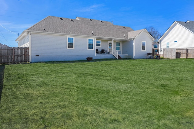 rear view of property with a patio area, a yard, a fenced backyard, and a shingled roof