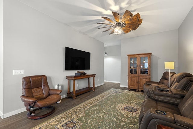 living room featuring ceiling fan, baseboards, and wood finished floors