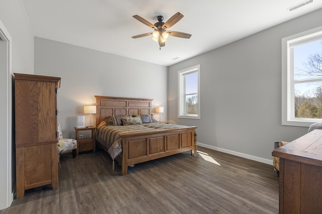 bedroom featuring visible vents, multiple windows, baseboards, and dark wood finished floors