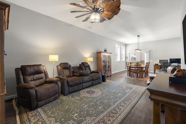 living area featuring visible vents, baseboards, a ceiling fan, and wood finished floors