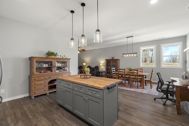 kitchen with wooden counters, baseboards, decorative light fixtures, gray cabinets, and dark wood-style floors