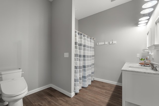 full bathroom featuring vanity, toilet, wood finished floors, and baseboards