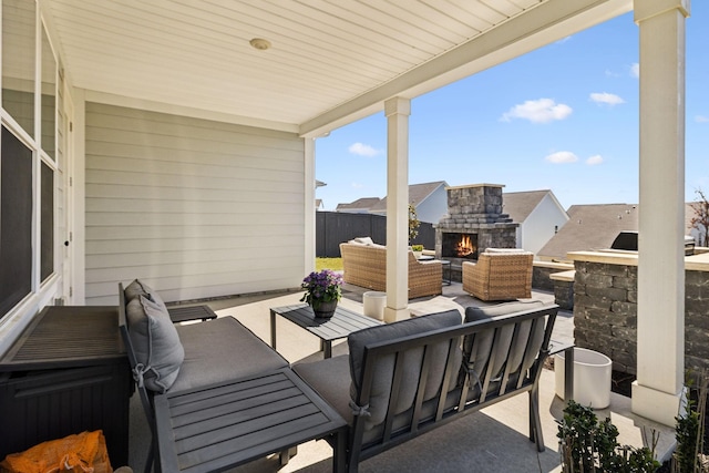 view of patio / terrace with fence and an outdoor living space with a fireplace
