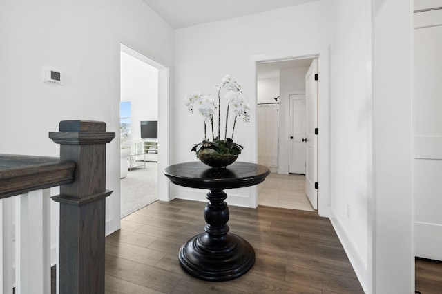 corridor with baseboards and wood finished floors