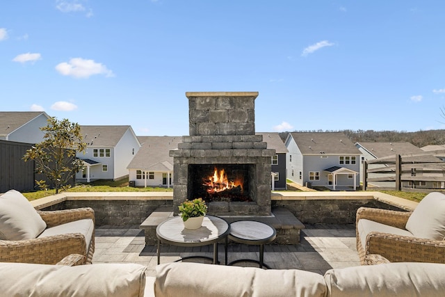view of patio featuring a residential view, fence, and an outdoor living space with a fireplace