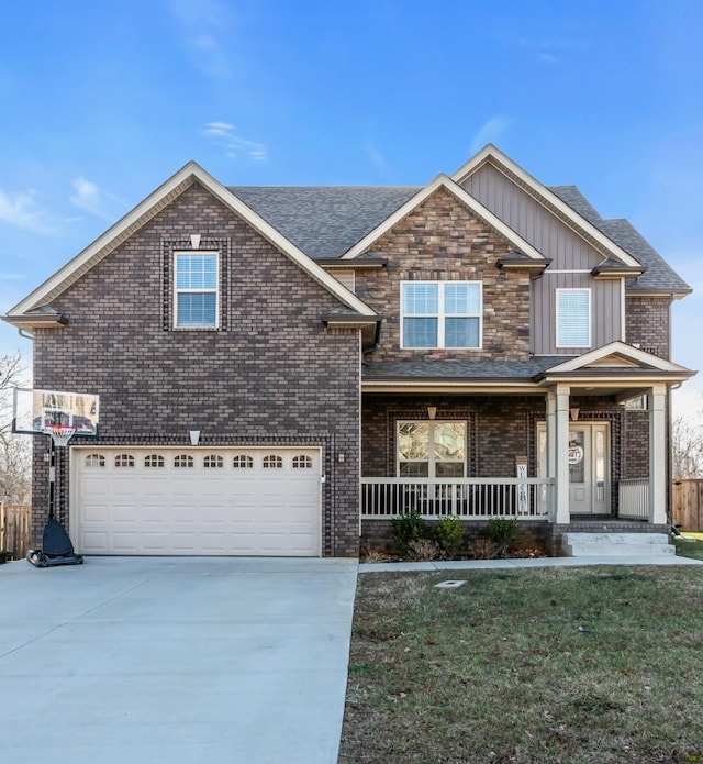 view of front of house with board and batten siding, a front lawn, a porch, driveway, and an attached garage