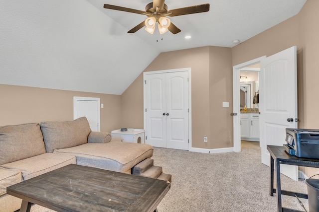 living area featuring baseboards, lofted ceiling, light colored carpet, and a ceiling fan