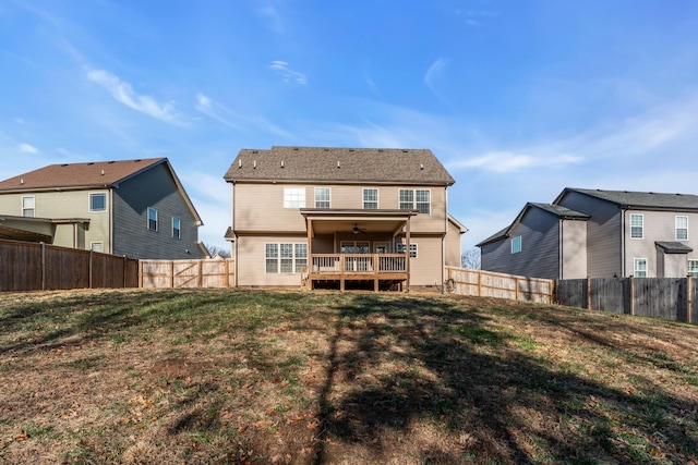 rear view of property featuring a lawn, a ceiling fan, and a fenced backyard