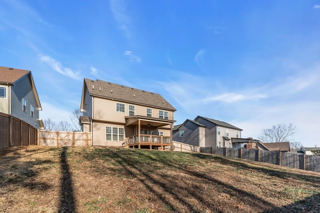 back of property featuring a deck, a lawn, and a fenced backyard