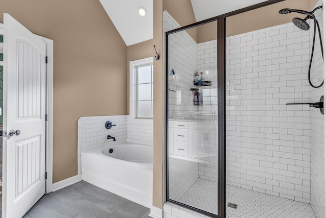 bathroom featuring baseboards, a stall shower, vaulted ceiling, a garden tub, and tile patterned floors