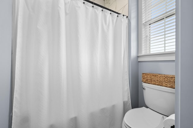 full bathroom featuring toilet and shower / tub combo with curtain
