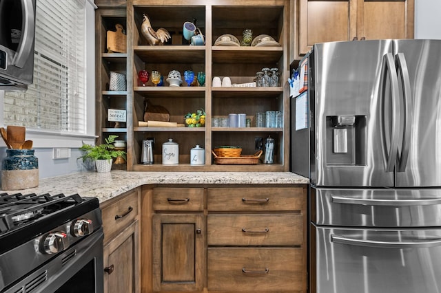 kitchen featuring open shelves, light stone counters, brown cabinets, and stainless steel fridge with ice dispenser