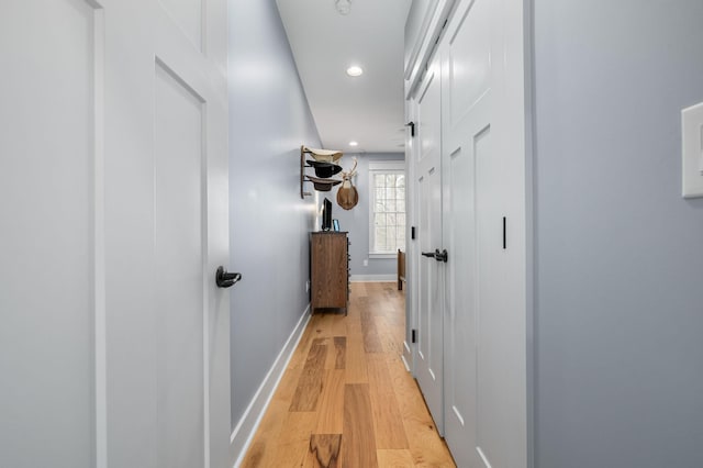 hallway with recessed lighting, light wood-style floors, and baseboards