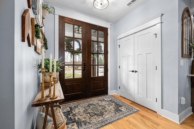entryway featuring visible vents, light wood-type flooring, and baseboards