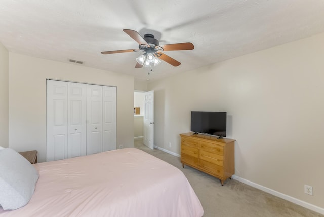 bedroom featuring visible vents, baseboards, light colored carpet, and a closet