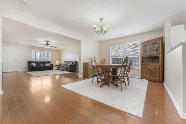 dining room featuring plenty of natural light, baseboards, and light wood finished floors