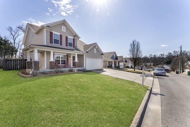 view of front of house with a porch, concrete driveway, fence, and a front yard