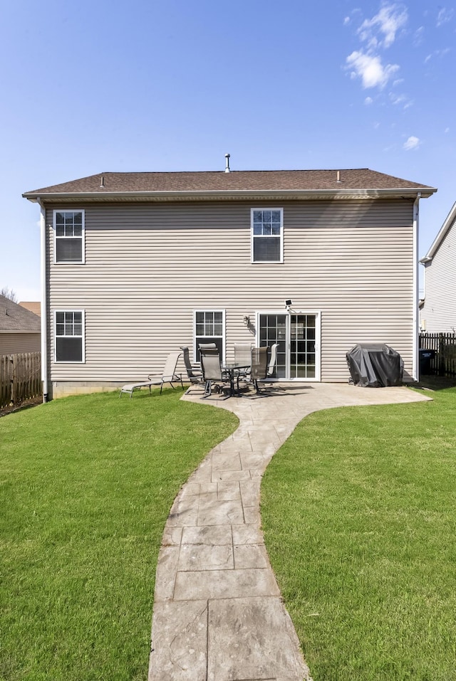 back of property with a patio area, a lawn, and fence