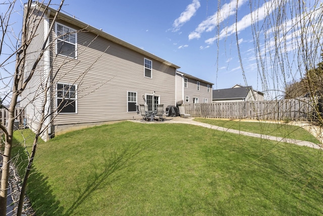 rear view of property with a patio area, a yard, and fence