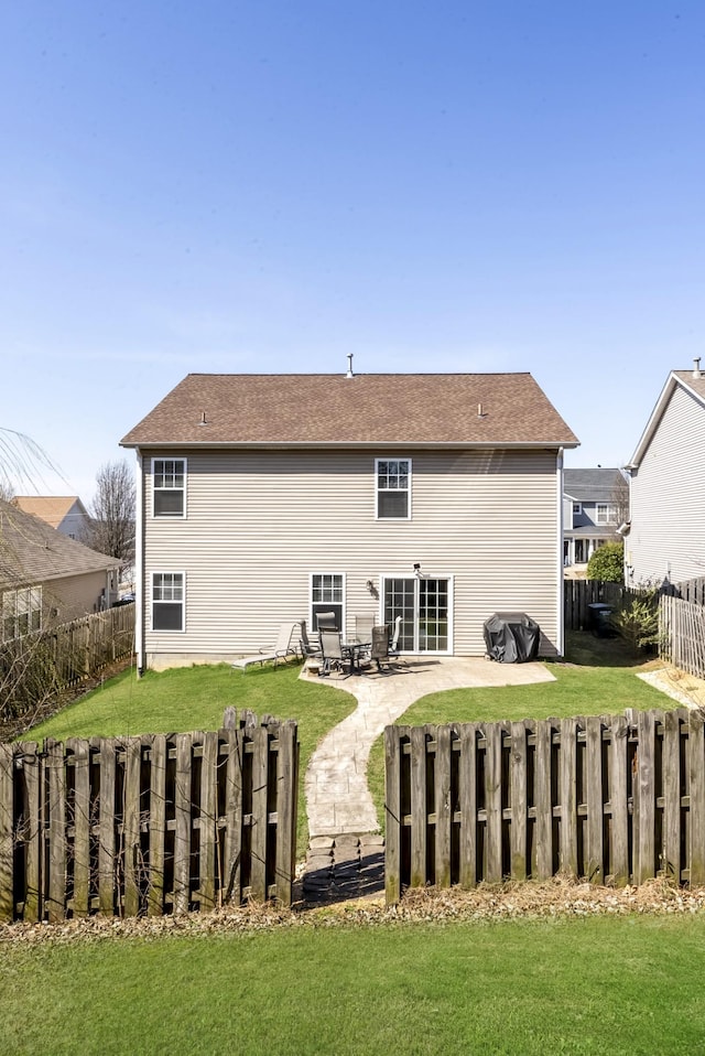 rear view of house with a yard, a patio area, a fenced backyard, and roof with shingles