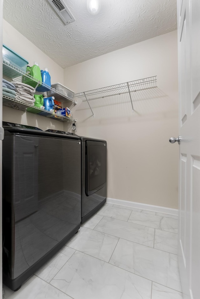 washroom featuring washing machine and clothes dryer, visible vents, baseboards, laundry area, and marble finish floor