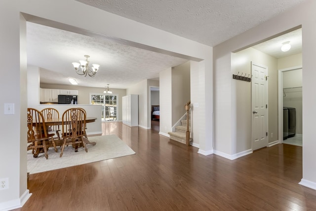 dining space featuring a notable chandelier, a textured ceiling, wood finished floors, stairway, and baseboards